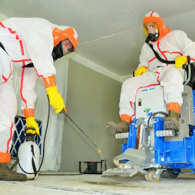 employé en train de traiter l'amiante un endroit clos habillé en combinaison