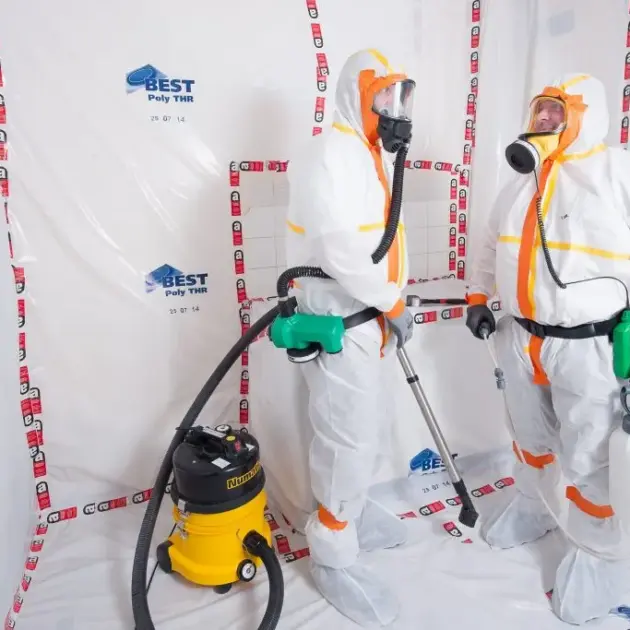 travailleurs sur un chantier entrain de traiter de l'amiante habillé en combinaisons spéciale pour l'amiante