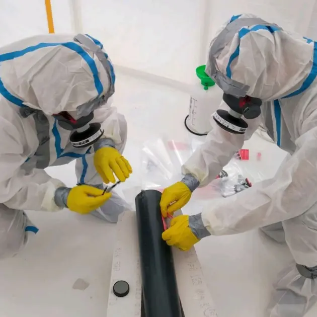 deux travailleurs entrain d'opérer sur un objet contenant de l'amiante