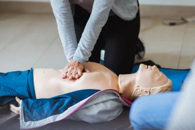 personne entrain de se former sur un faux mannequin à un massage cardiaque dans le cadre d'une formation sst