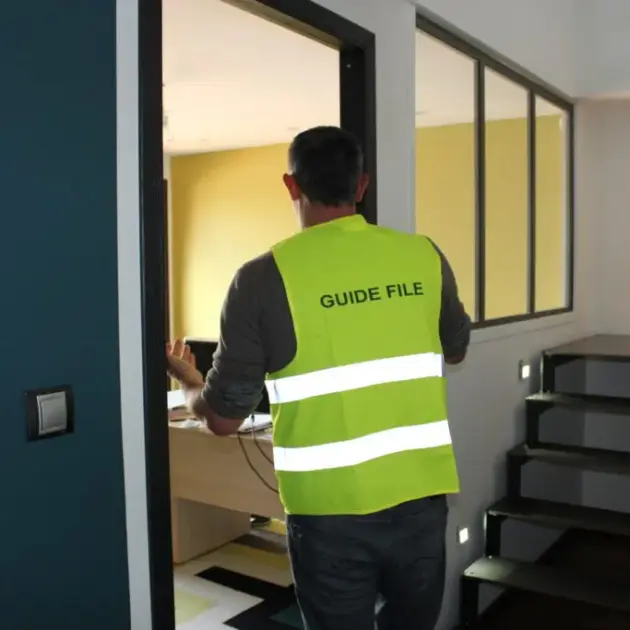 formateur avec un gilet écris guide file dans la dos d'un gilet jaune