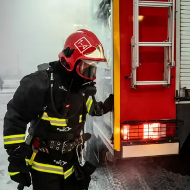 pompier en tenue d'intervention d'incendie à l'arrière d'un camion