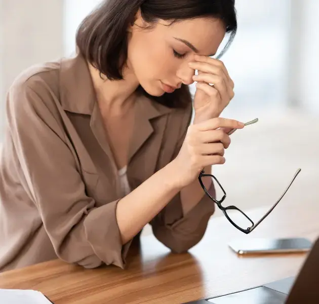 femme sur un bureau en train de souffrir à cause de problème psychosociaux