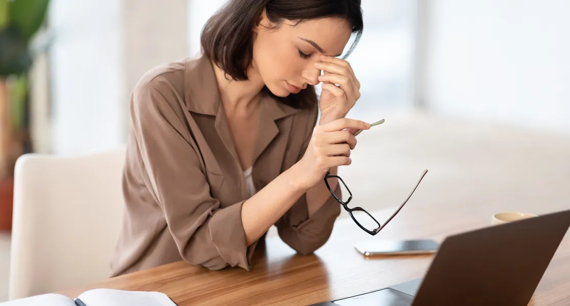 femme sur un bureau en train de souffrir à cause de problème psychosociaux