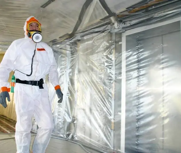 employé dans une salle en train de traiter l'amiante dans une salle